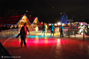 Menschen auf der Eislaufbahn rund um den Neptunbrunnen